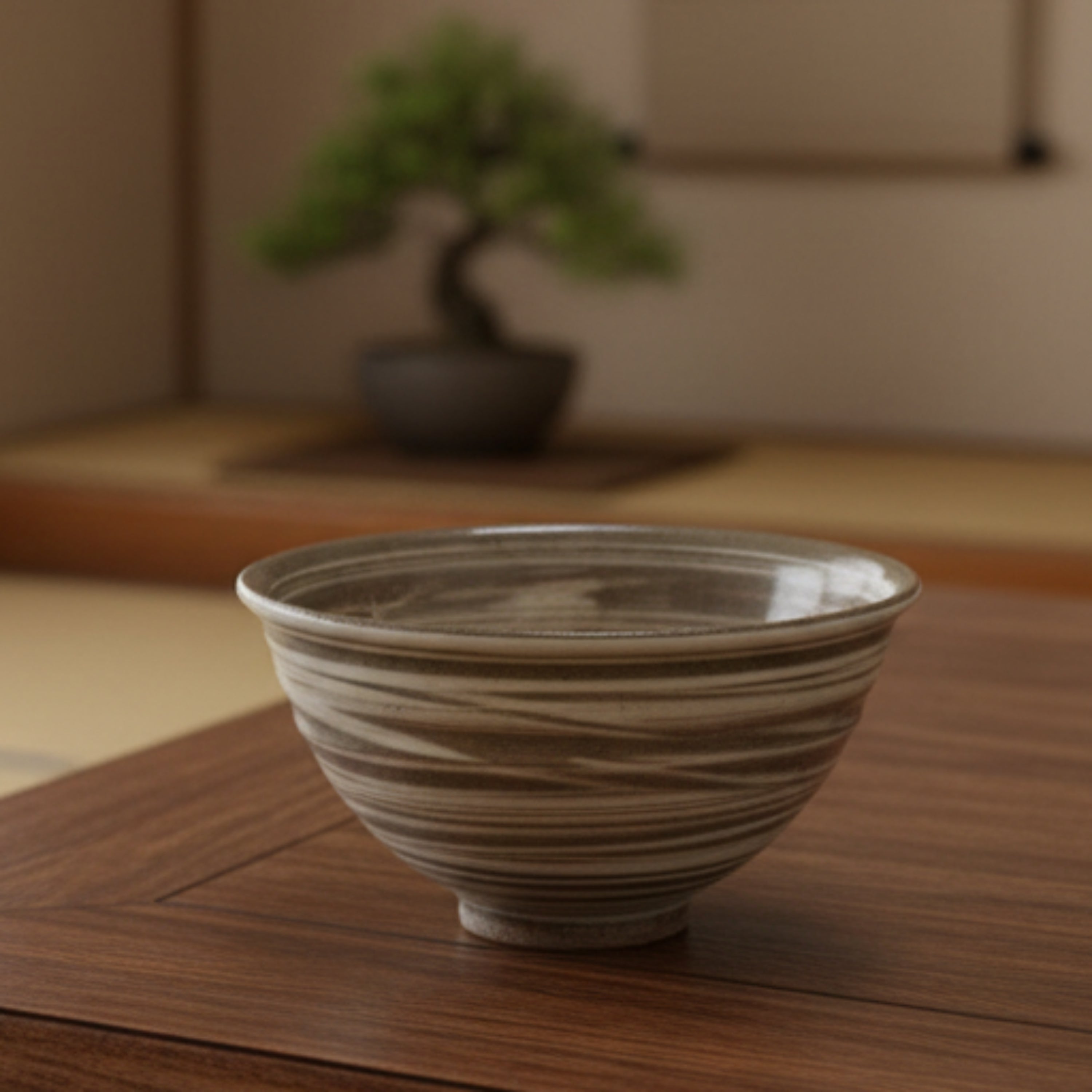 A Japanese pottery tea bowl with beautiful internal decoration and a wonderful swirling glaze on the outside.
