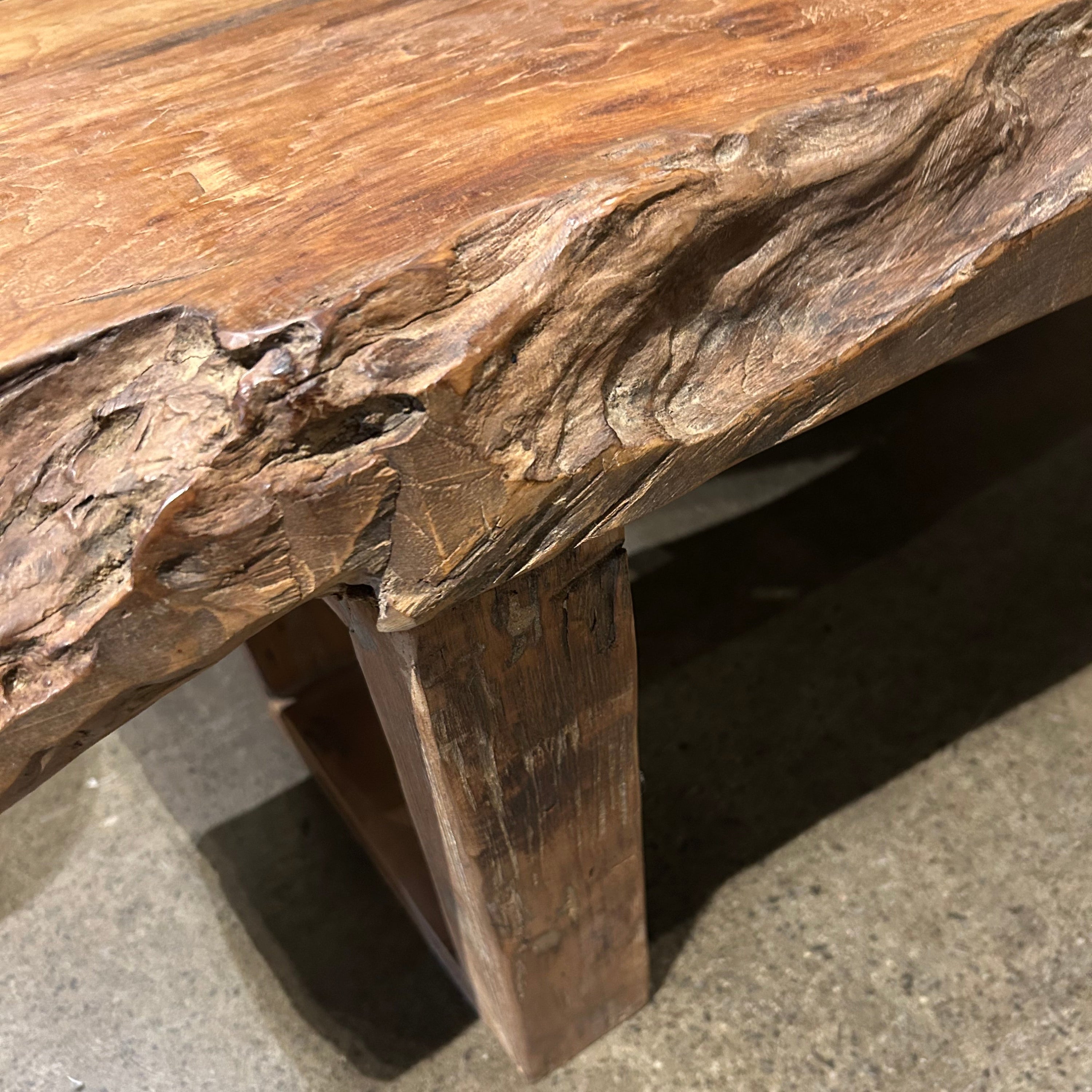 A rustic yet substantial natural form coffee table made of recycled timber.