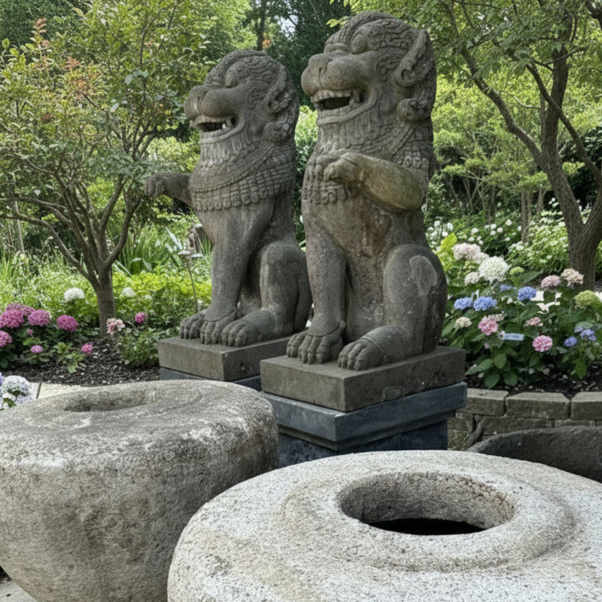 Two large garden pots in the foreground with two large guardian lions in the background in a beautiful garden