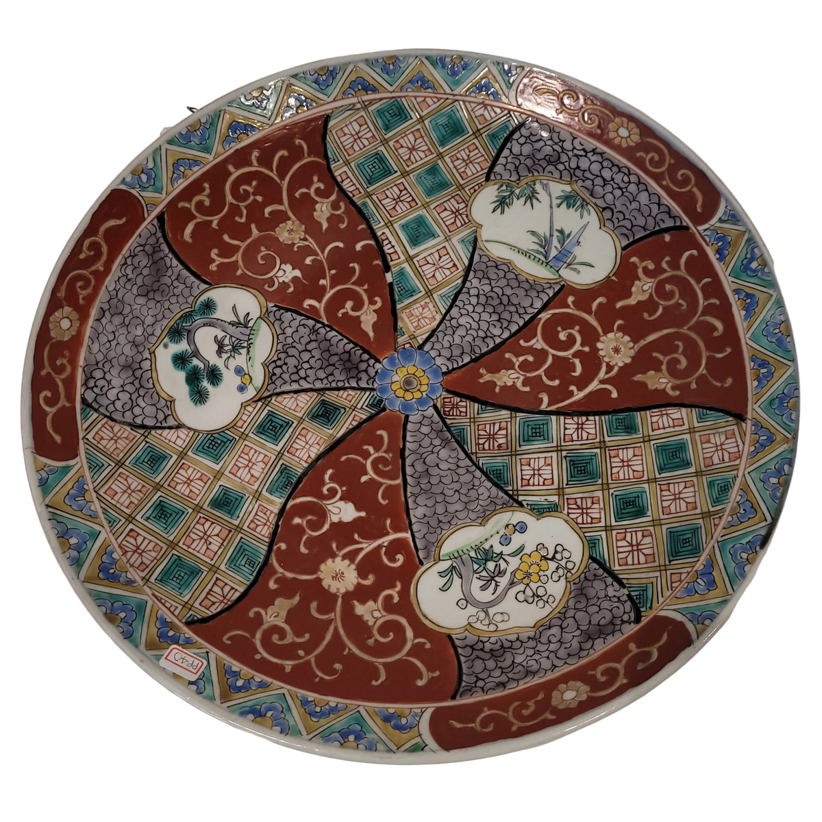 A round ceramic plate featuring an intricate Japanese Imari pattern with red, gray, green, and gold sections, decorated with floral and bird motifs.