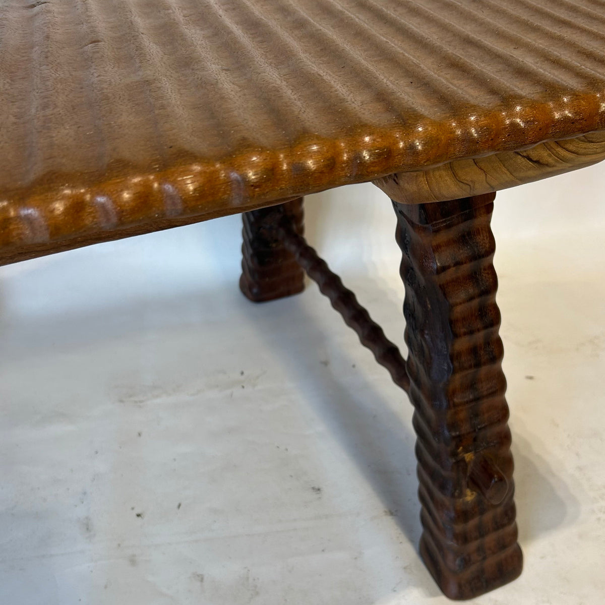 This unique and substantial coffee table is crafted from teak wood, celebrating the natural beauty and character of the wood. Its solid construction give it a strong, grounded presence.