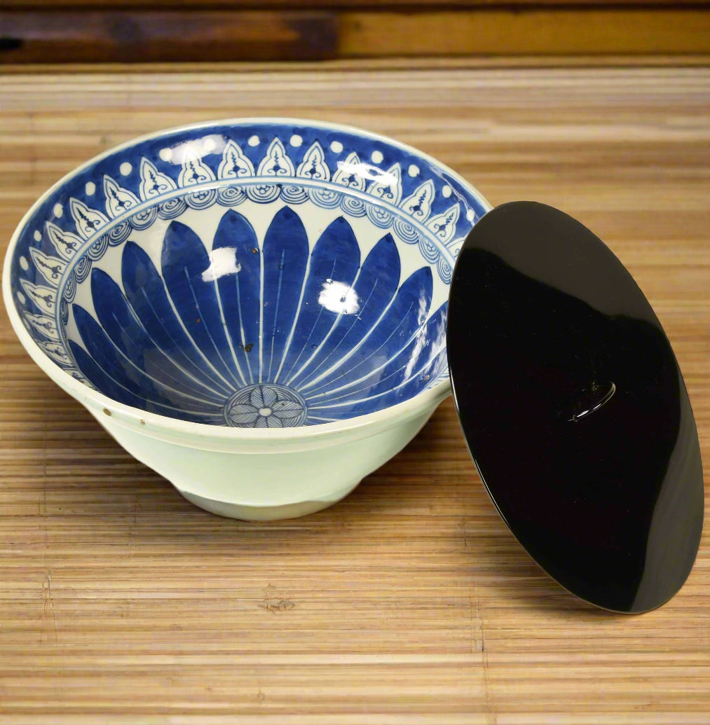 A Japanese celadon bowl with blue and white underglazed patterned interior, converted into a mizusashi by the addition of a detached black lacquer lid. Meiji period, late 19th century.