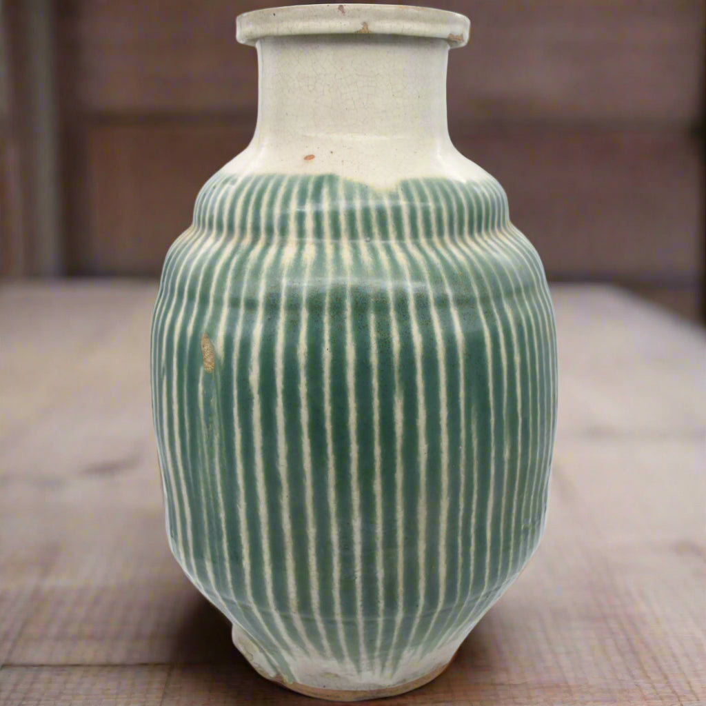 Antique Japanese green and white striped shigaraki tea jar, there is a small hole at the bottom of the jar for a plug or tap. Meiji period, late 19th century.