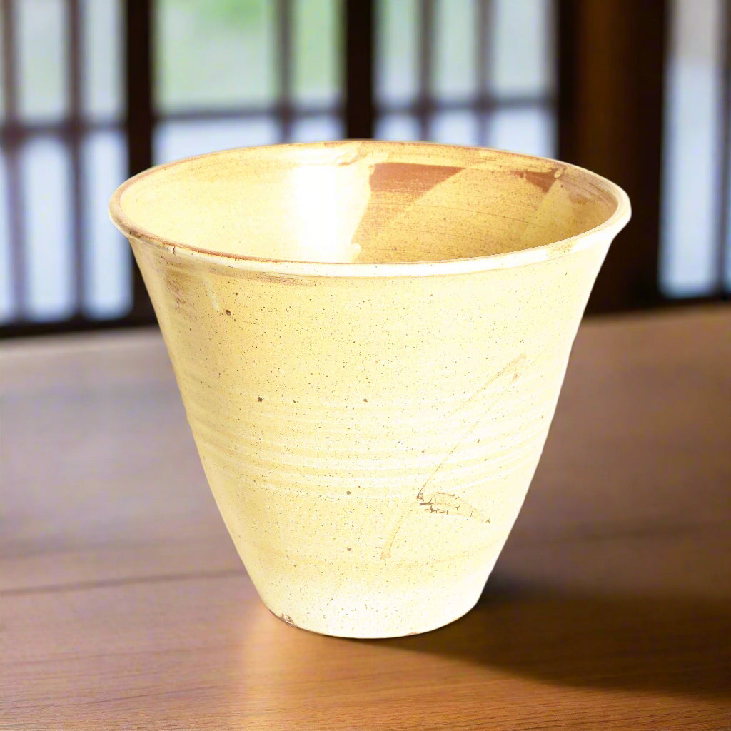 A Japanese studio pottery vase with a hand painted sheaf of wheat on a creamy yellow glaze.