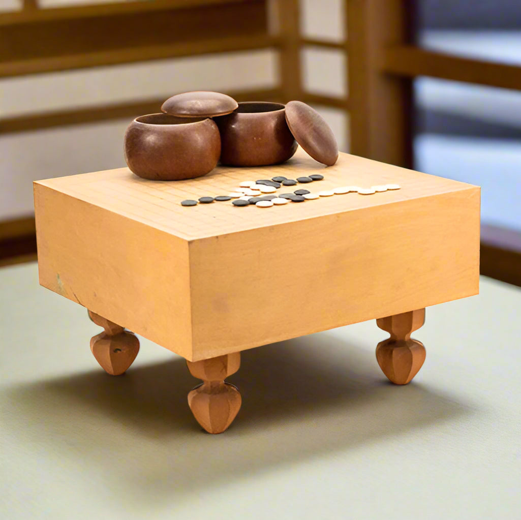 Japanese Go board game set.

Beautiful sturdy board with white and black stones with natural wood bowls. We have several of these to select from in our store.